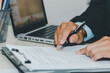© khunkornStudio - Business Man using computer laptop and pen paperwork document a desk. Business finance, tax, and investment concepts.