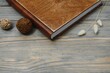 © Serhii - Family photo book with embossing. Photo book on a wooden background. Brown photo book with wood cover. Photoalbum with a hard cover. Wedding photo album.