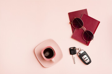 Preparing for a car trip. Passports, sunglasses, car keys and a cup of coffee on a pink background. Local tourism. Top view. Copy space