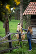 © Inuk Studio/Stocksy - Young woman petting horse next to rural countryside stable