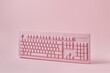 © Yaroslav Danylchenko/Stocksy - Vertically standing papercraft pink keyboard.