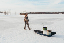 Boy Ice Fishing On A Pond In The Winter
