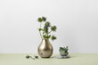 © Yaroslav Danylchenko/Stocksy - Healing green mineral ore crystals and flowers in vase