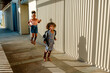© Erin Brant/Stocksy - Sisters jumping on sidewalk