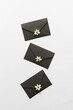 © Yaroslav Danylchenko/Stocksy - Black envelopes with blooming white flowers