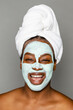 © McKinsey Jordan/Stocksy - Laughing Woman Wearing Clay Face Mask And Towel
