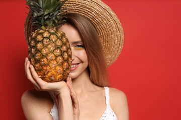 Poster - Young woman with fresh pineapple on red background, space for text. Exotic fruit