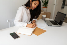 Woman Writing In Her Notebook At Office