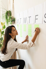  Woman Writing In A Weekly Wall Organizer 