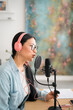 © Studio Marmellata/Stocksy - Woman recording podcast in modern studio