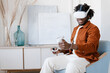 © Alina Hvostikova/Stocksy - Black man playing video game in virtual reality