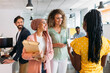 © VICTOR TORRES/Stocksy - Smiling multiracial colleagues walking in corridor of contemporary office