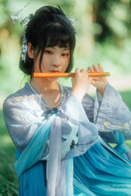 Asian Teenage Girl Playing Bamboo Flute