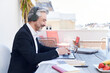 © Ivan Gener/Stocksy - Smiling businessman using a laptop with headphones