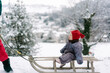 © Léa Jones/Stocksy - baby girl sitting  on a sled in the snow
