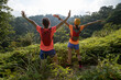 © lzf - Two women trail runners open arms to surnise after running to the top of tropical forest mountain