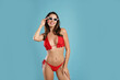 © New Africa - Beautiful woman in stylish bikini and sunglasses on blue background. Space for text