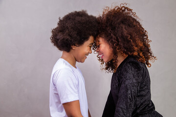 Wall Mural - Portrait of young African American mother with toddler son. Grey background. Brazilian family.