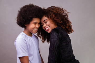 Wall Mural - Portrait of young African American mother with toddler son. Grey background. Brazilian family.