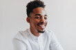 © Look! - Optimistic man smiling on isolated background. Cool brunette man in white shirt laughing. Portrait of dark-skinned guy