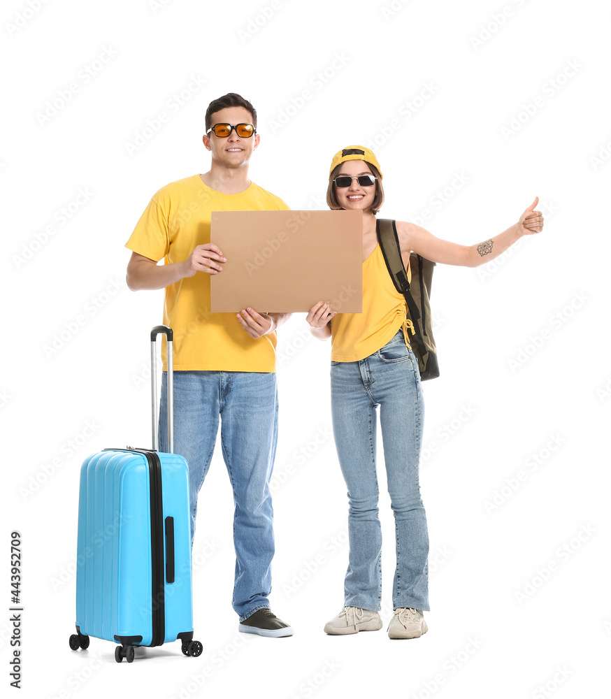 Young couple with cardboard and suitcase hitchhiking on white background