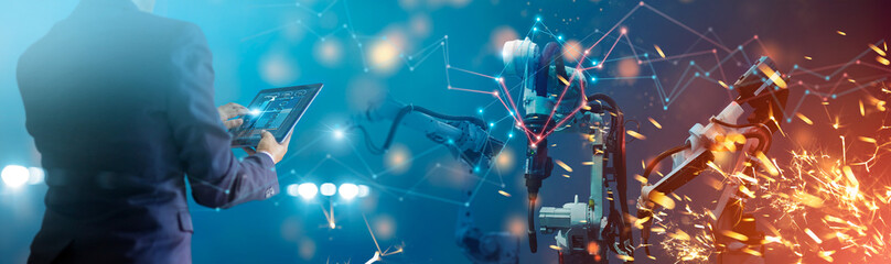 Fototapete - Manager engineer check and control automation robot arms machine in intelligent factory industrial on real time monitoring system software. Welding robotics and digital manufacturing operation.