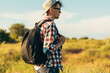© Shopping King Louie - Smiling young man wearing glasses and cap traveling with backpack in summer, hiker hiking and observing picturesque landscape