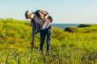 © Shopping King Louie - Smiling young man with a backpack stands on the trail looking at the panorama while walking alone, Tourist with a backpack looking