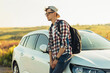 © Shopping King Louie - Young man traveler enjoying the beautiful landscape during summer adventure, Male traveler standing near the car outdoors in nature