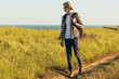 © Shopping King Louie - Smiling young man wearing glasses and cap traveling with backpack in summer, hiker hiking and observing picturesque landscape