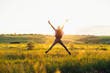 © Shopping King Louie - Rear view of man jumping up with outstretched arms, happy man with arms up against blue sky background, outdoors