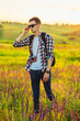 © Shopping King Louie - Young male tourist, in sunglasses, with a camera, in nature, spending time in a hike, on the field