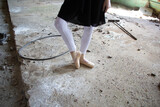 Fototapeta Tęcza - woman legs in pointe shoes and white leggins on grunge concrete floor of abandoned building