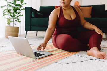 Wall Mural - Body positive woman watching online workout video on laptop