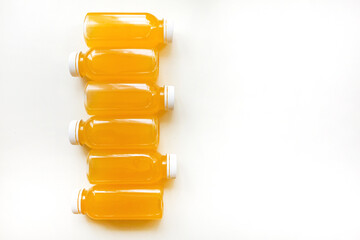 Bottles of freshly squeezed orange juice on a white background. The concept of a healthy diet, detox or diet