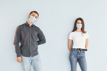 Man and woman standing indoors in the studio against white background