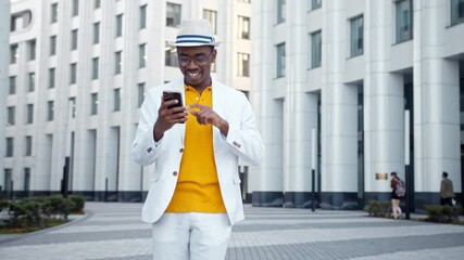 Wall Mural - African American guy in suit takes smartphone and dances