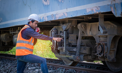 Engineer under inspection and checking construction process railway switch and checking work on railroad station .Engineer wearing safety uniform and safety helmet in work.