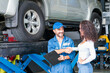 © Thirawatana - Service repair maintenance concept. The car mechanic is explaining the operation of the engine. Smiling mechanic shaking hands at auto service.