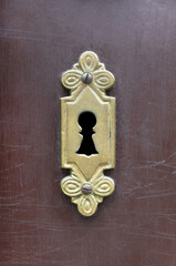 A vintage antique keyhole in old scratched wooden door