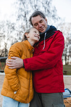 Smiling Father And Daughter Embracing In Park