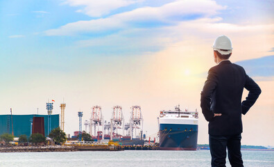 Businessman standing at a port of its own, Back view of a young confident man financier is thinking about something, while is standing outdoors against sea port.