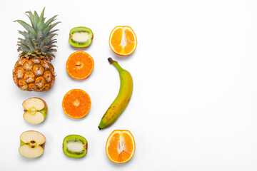 Wall Mural - Banana, orange, kiwi, apple and pineapple creative mockup on light background. Healthy eating. View from above. Copy space.