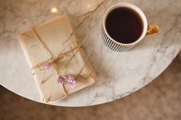 Wall Mural - Cup of black tea with laced stack of old love paper letters on marble table close up. Top view. Romance concept. Valentines Day. Snail mail.