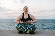 © Ezequiel Giménez/Stocksy - Curvy woman doing breathing exercise on embankment