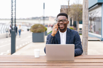 Businessman using his phone outdoors in a cafe 
