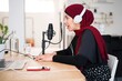 © Studio Marmellata/Stocksy - Muslim woman speaking in mic and recording podcast
