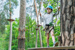 © speed300 - Attractive, little boy in insurance and a protective helmet stands on a suspension road. The child actively spends time