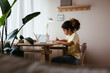 © BONNINSTUDIO/Stocksy - Glad Hispanic girl sitting at table and drawing