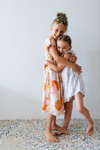 Two Sisters Giving A Hug While Playing With Confetti